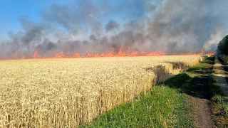 Горящее после российского обстрела поле пшеницы в Николаевской области Украины 
