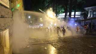 Полиция применяет слезоточивый газ и водометы, пока демонстранты пытаются заблокировать боковой вход в парламент Грузии.