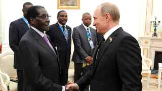 Владимир Путин (справа), вероятно, хотел бы править до 93 лет, как Роберт Мугабе (слева)