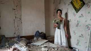31-летняя тренер по йоге Дарья Стенюкова позирует во время свадебной фотосессии в своей разбомбленной квартире в Виннице, которая в прошлом месяце пострадала от российских авиаударов.
